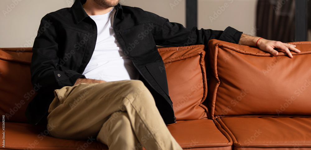 Casual handsome young man relaxing at home sitting on the couch. Casual handsome young man relaxing at home sitting on the couch.