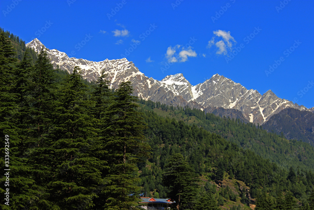 Snow clad himalayas viewed from The Beas River in Manali from Leh - manali highway in summer morning of May, India.Himachal Pradesh
