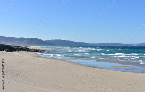 Wild Atlantic Ocean beach with furious sea  waves breaking and blue sky. Arteixo  Coru  a  Galicia  Spain.