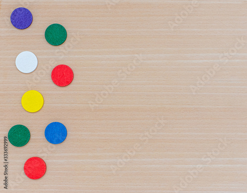 Various multi-colored geometric shapes on a wooden background. View from above. Background for text. Copy space