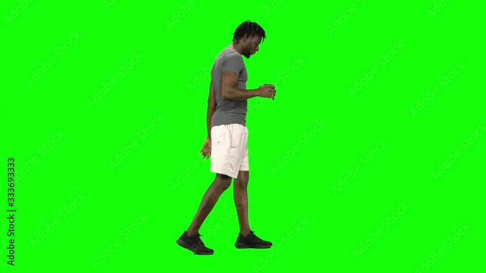 African american man walking and drinking coffee at Green Screen, Chroma Key. Profile view. African american man walking and drinking coffee at Green Screen, Chroma Key. Profile view.