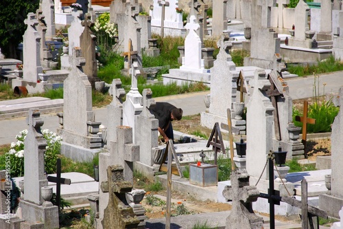 Man tending grave in Romanian cemetery