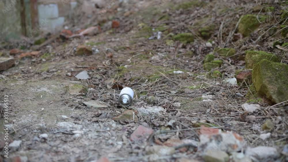 an empty spray can drops next to the teenager s feet and the guy leaves. The boy threw the empty spray can out of the paint and left an empty spray can drops next to the teenager s feet and the guy leaves. The boy threw the empty spray can out of the paint and left