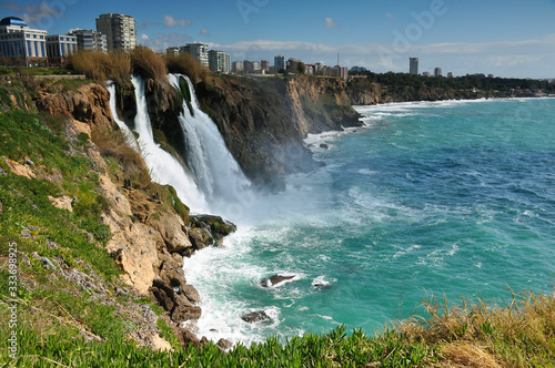 Waterfall on city coast close-up. Travel, beauty, sea