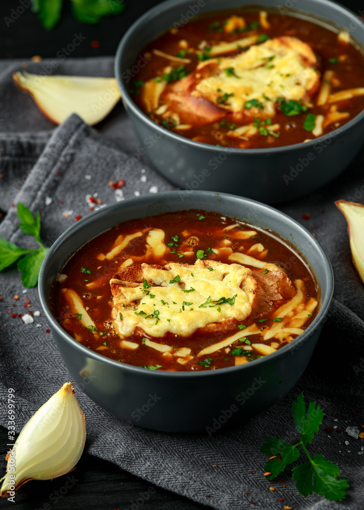 French onion soup with cheese toast on rustic background