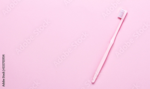 Pink toothbrush on pink background. Taking care of teeth, dental concept. Flat lay photo, copy space, top view,minimalism.