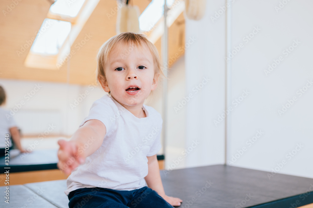 White T-shirt on a cute little smiling boy, on white background. Positive emotions hugging head little child. White T-shirt on a cute little smiling boy, on white background. Positive emotions hugging head little child.