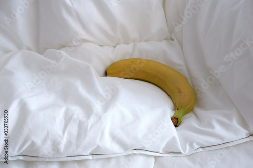 banana on the bed linen. The white texture. Minimalism. Coziness.