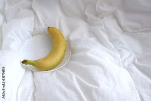 banana on the bed linen. The white texture. Minimalism. Coziness.