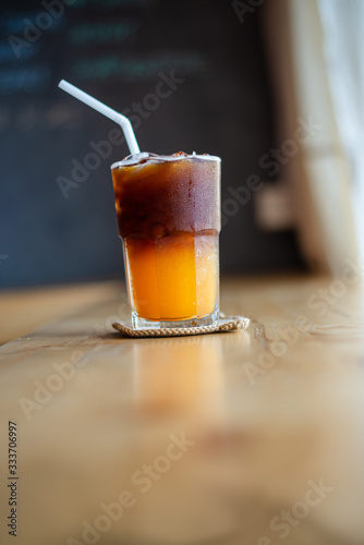 Ice coffee, americano coffee with orange in cafe.