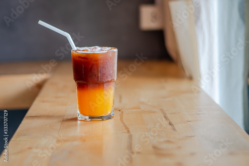 Ice coffee, americano coffee with orange in cafe.