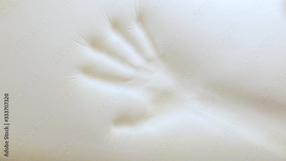 Mano sta toccando un letto in poliuretano con tecnologia memory foam.