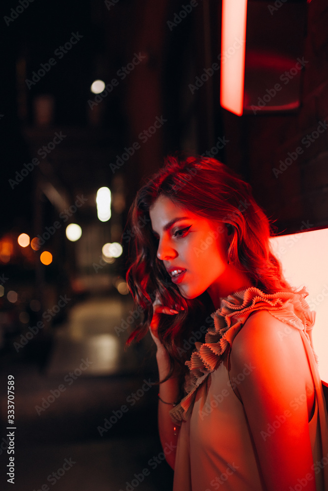 a young girl in a summer dress walks around the city at night a young girl in a summer dress walks around the city at night