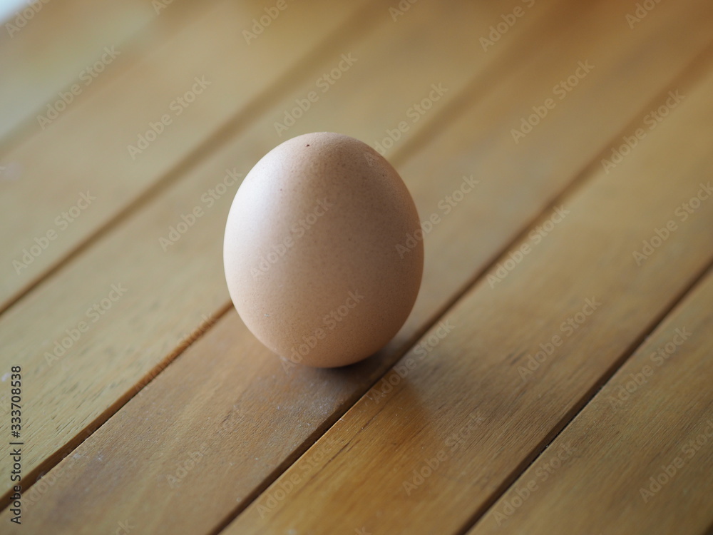 Fresh egg on brown wooden desk