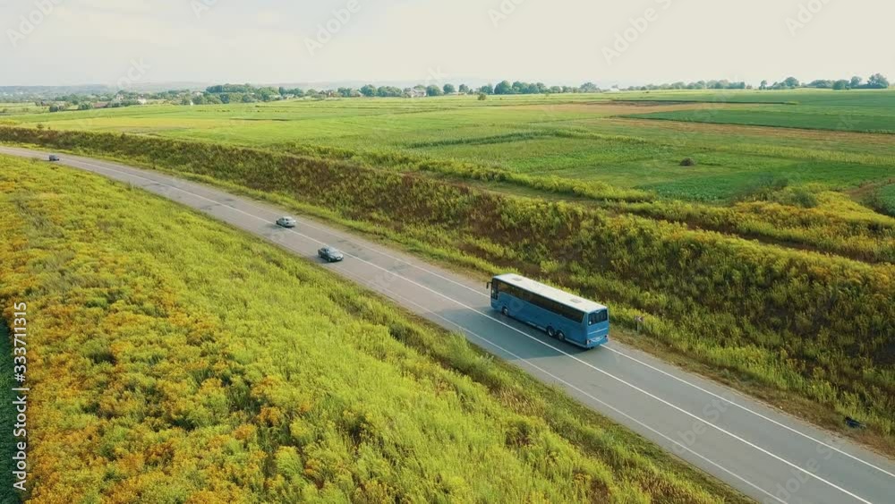 Aerial view of tour bus on a narrow countryside road.