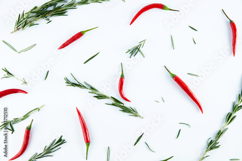Rosemary and chili peppers on a white background, top view. Spices, seasonings