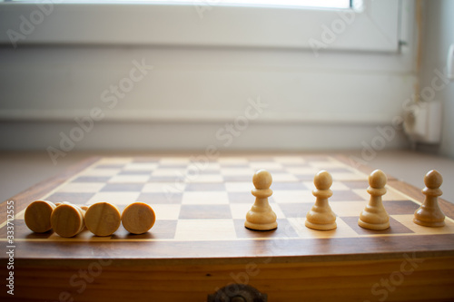 Concept of social distancing and its benefits  with four chess pawns fallen and four spread and standing