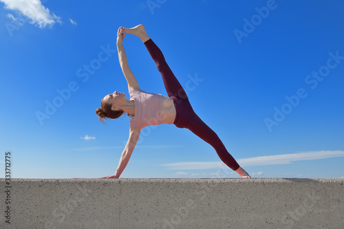 Portrait of a fit woman who practices yoga outdoors. Woman practicing asanas on a sunny day