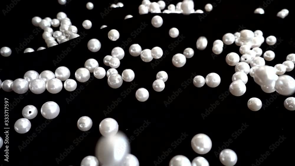 White pearls fall. Slow motion. White pearls fall. Slow motion.