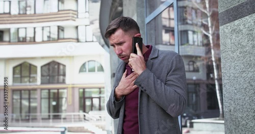 Man talking on the phone near office centre and starts to cough with dyspnea photo