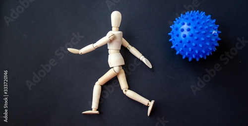 COVID-19 Pandemic Coronavirus concept ; wooden model of a man running away from a coronavirus model
