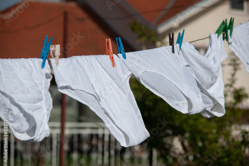 Underpants. Identical white underpants hung on the garden after the laundry. Same underwear dry outdoor.