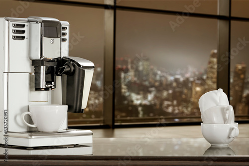 Coffee machine in office and blurred window of city at night 