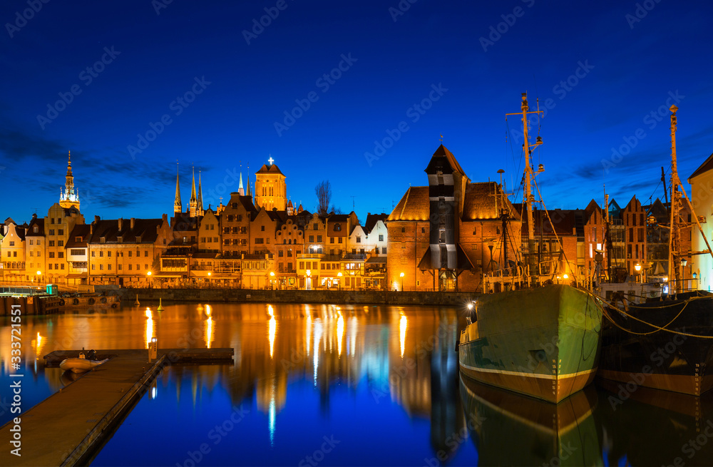 Old town in Gdansk with historical port crane over Motlawa river at night, Poland.