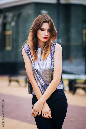 Beautiful, young, fashionable girl on the background of the building. Street fashion photo. Model with clean skin.