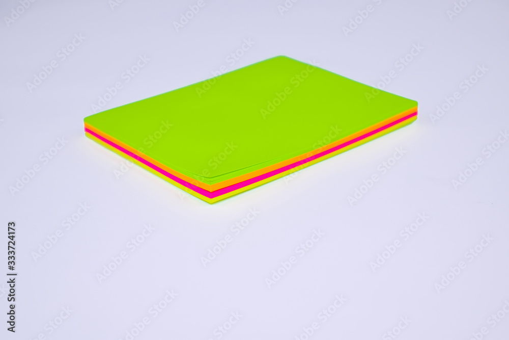 Fototapeta premium Top view of a stack of different colored paper sticky notes on top of a desk
