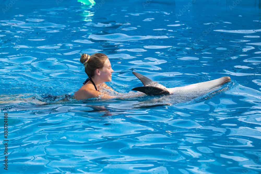 Naklejka premium Girl swimming with dolphin