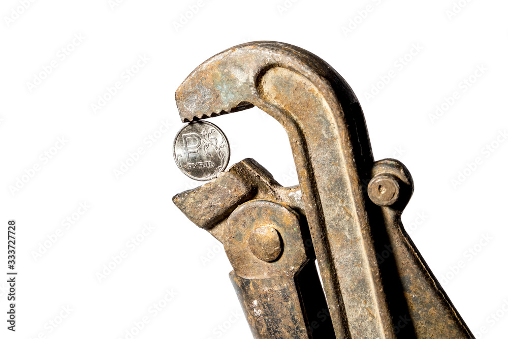 The ruble coin is clamped with a wrench on a white background The ruble coin is clamped with a wrench on a white background