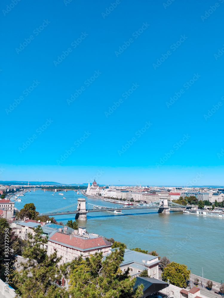 Amazing panorama of the city of Budapest on a sunny day. Bridge, river and small buildings. Vertical photo. Budapest, Hungary
