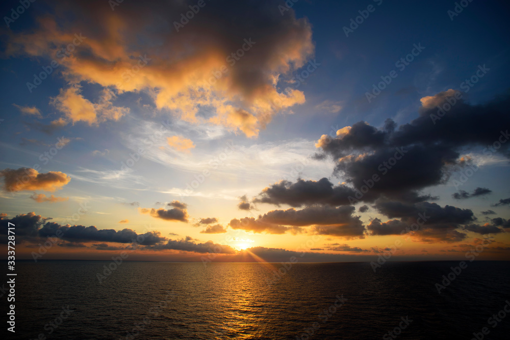 Cloudy sunset with light sun under the sea surface, tranquillity and calm
