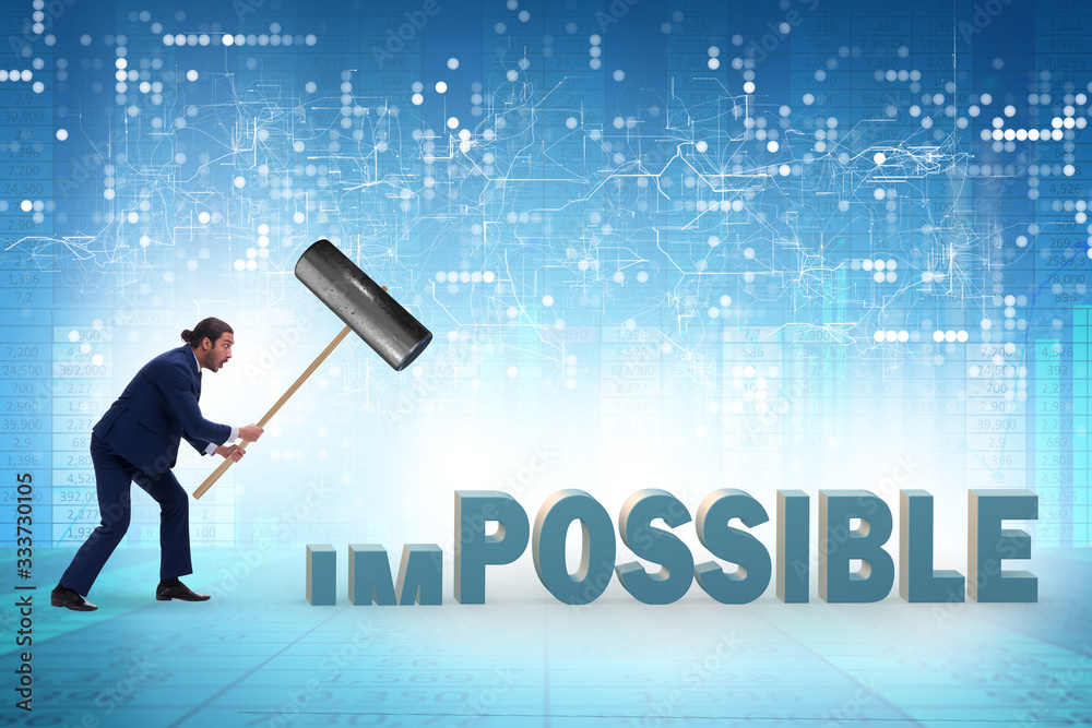 Businessman hitting the word impossible with hammer Businessman hitting the word impossible with hammer