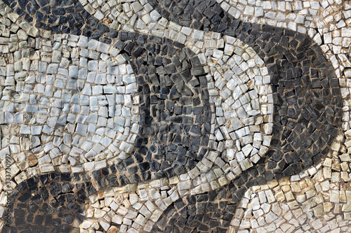 Vertical wave pattern of cobblestone boulevard sidewalk of Copacabana beach at early morning sunrise in Rio de Janeiro, Brazil. Close up with texture of real street walkway.