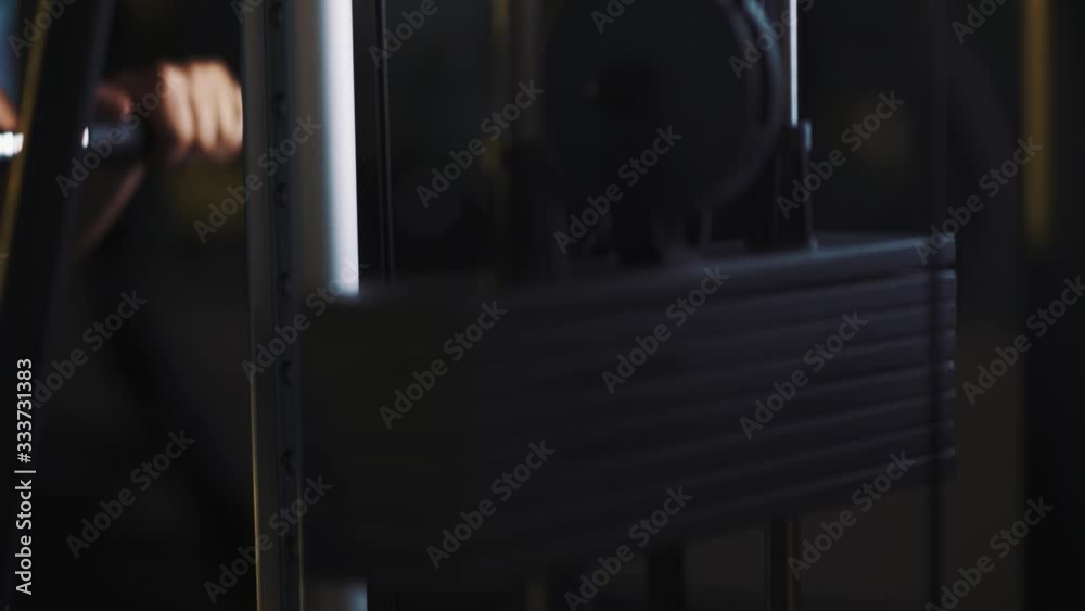 Strong muscular man doing lifting cable rope triceps push down exercise while working out in gym. Healthy athlete at the dark night gym in slow motion. Close up. 50 fps Strong muscular man doing lifting cable rope triceps push down exercise while working out in gym. Healthy athlete at the dark night gym in slow motion. Close up. 50 fps
