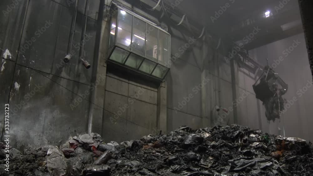 Crane collecting industrial garbage at a garbage center.