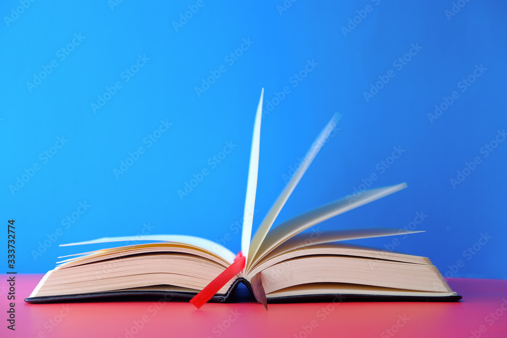 Naklejka premium Opened empty book on blue background, space for text.