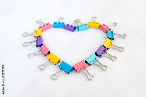 Heart of multicolored paper clips on a white background