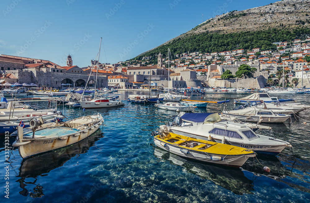 Boats in Old Town Harbour in Dubrovnik. View with Revelin Fortress and Dominican Monastery, Croatia
