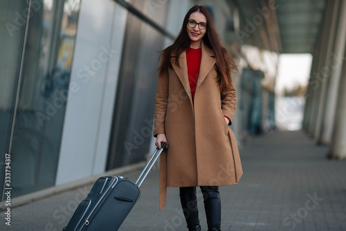 girl in a coat with a suitcase going to the landing zone