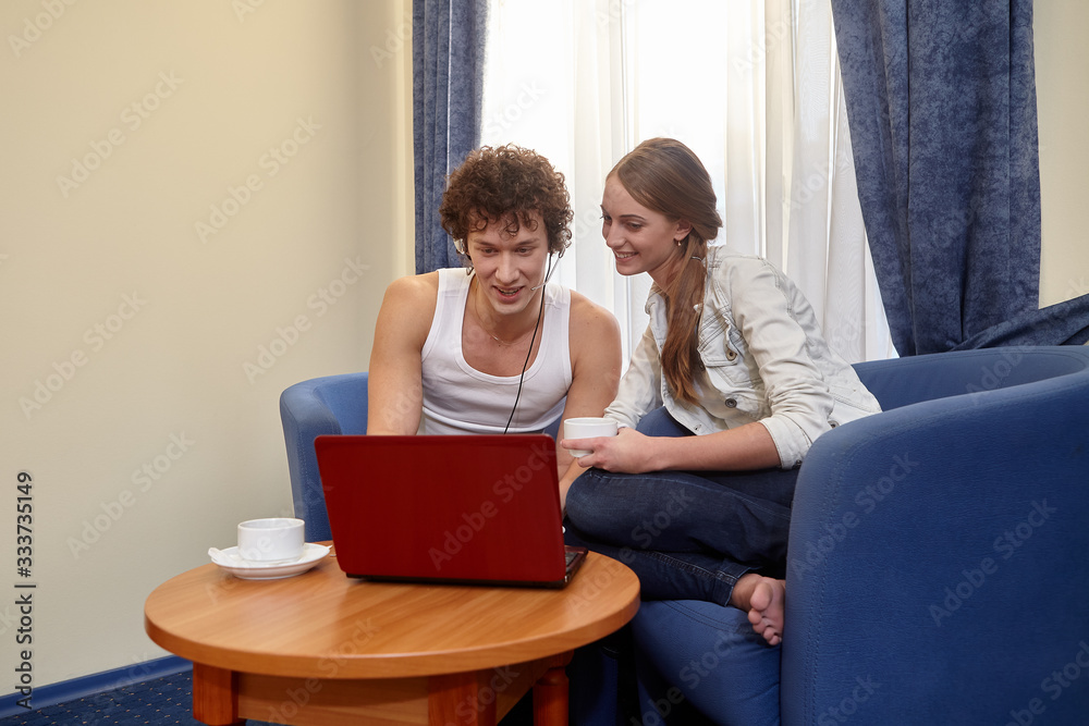 Young family with laptop are sitting in living room at home. Internet communication. Isolation period, social distancing Young family with laptop are sitting in living room at home. Internet communication. Isolation period, social distancing