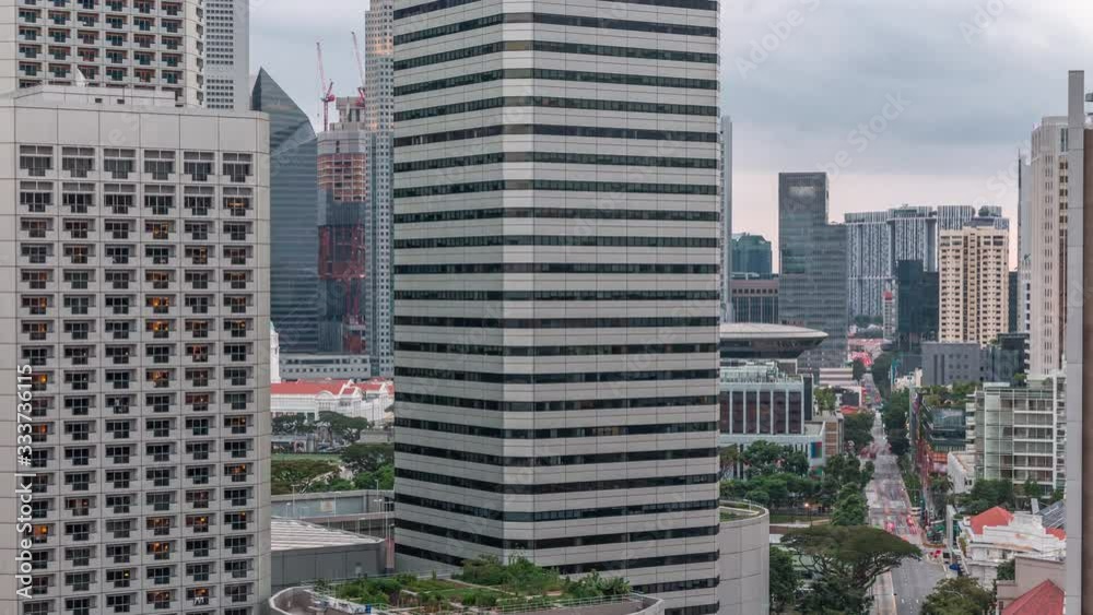 Evening panorama with Marina Bay area and skyscrapers city skyline aerial timelapse. The tower shape building at the North bridge road with traffic in Singapore.