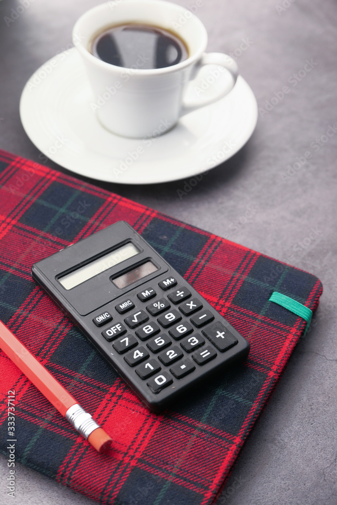 pencils, calculator notepad, and tea t on table at early morning pencils, calculator notepad, and tea t on table at early morning