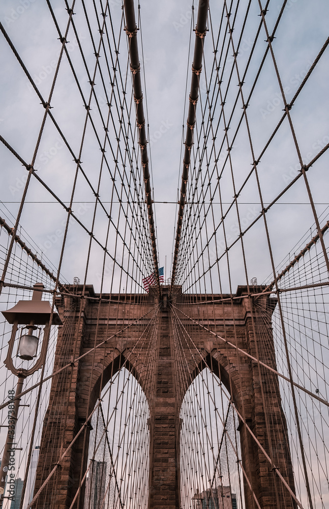Fototapeta premium Symetryczne liny stalowe i latarnia na moście Brooklyn Bridge