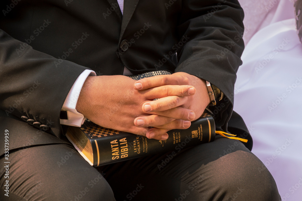 Lectura de la biblia, hombre sosteniendo la biblia entre sus manos y regazo