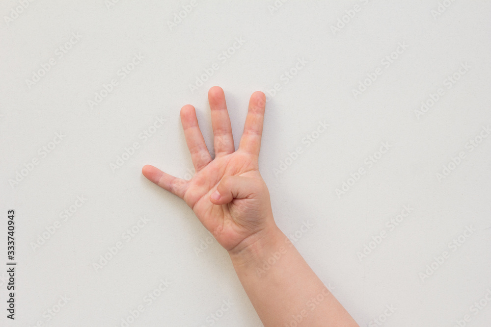Top view of child hand showing four fingers as number four on the white background Top view of child hand showing four fingers as number four on the white background