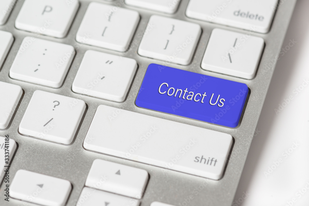 Blue button Contact Us on a white keyboard,business concept Blue button Contact Us on a white keyboard,business concept