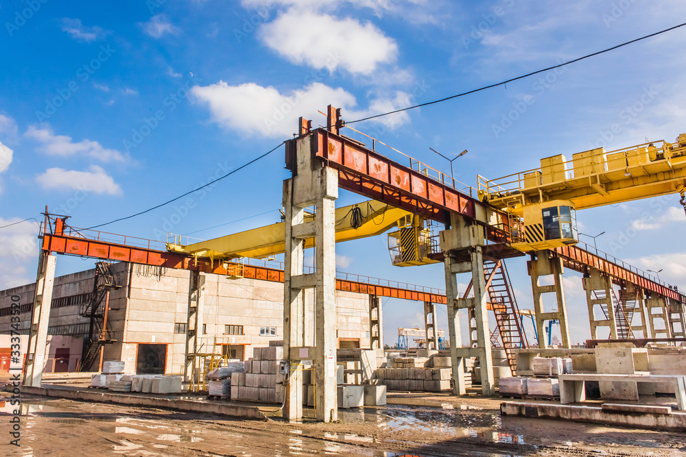Industrial area, site with bridge crane and concrete blocks, production background